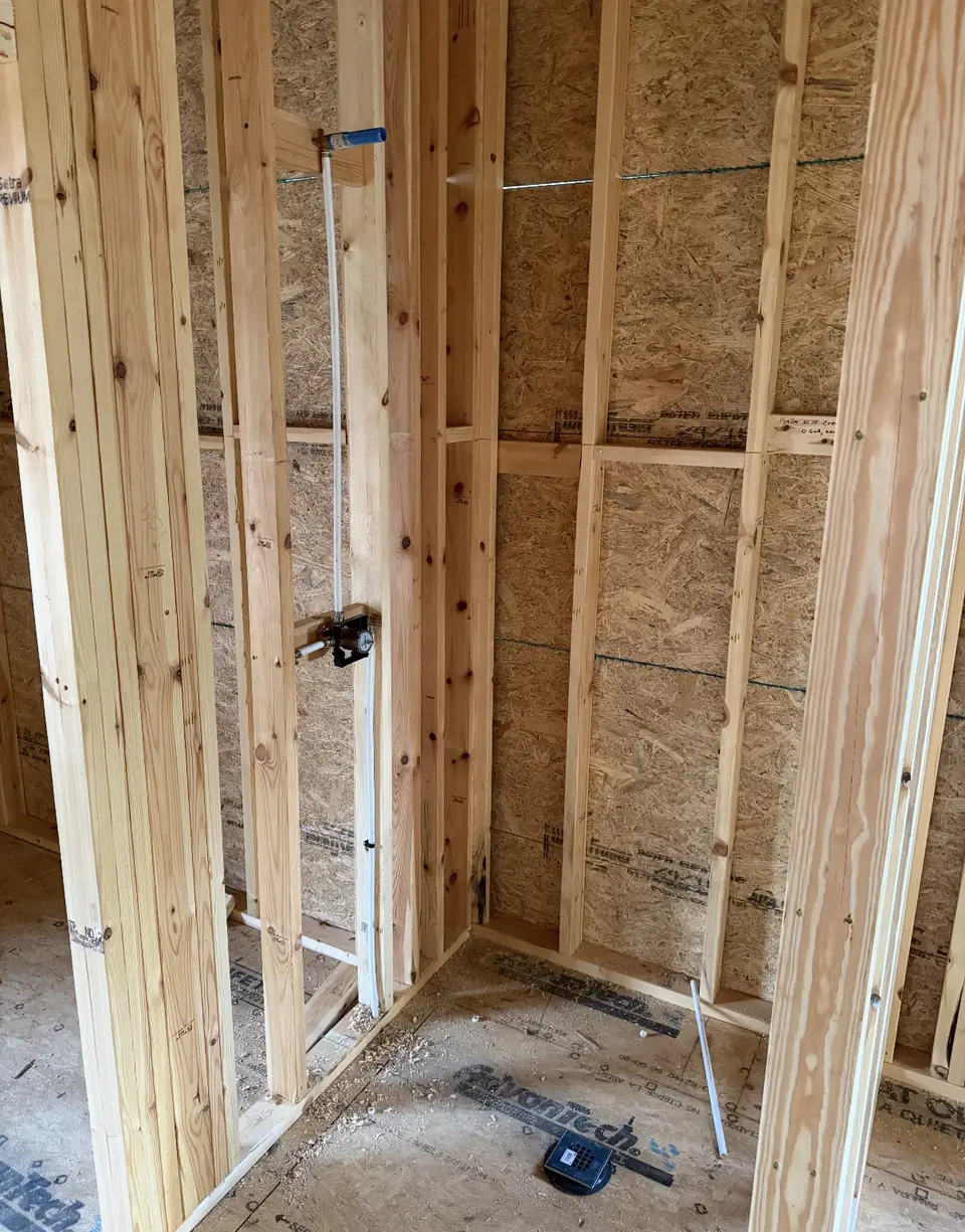 Drain and vent rough-in in the framed corner of a new house