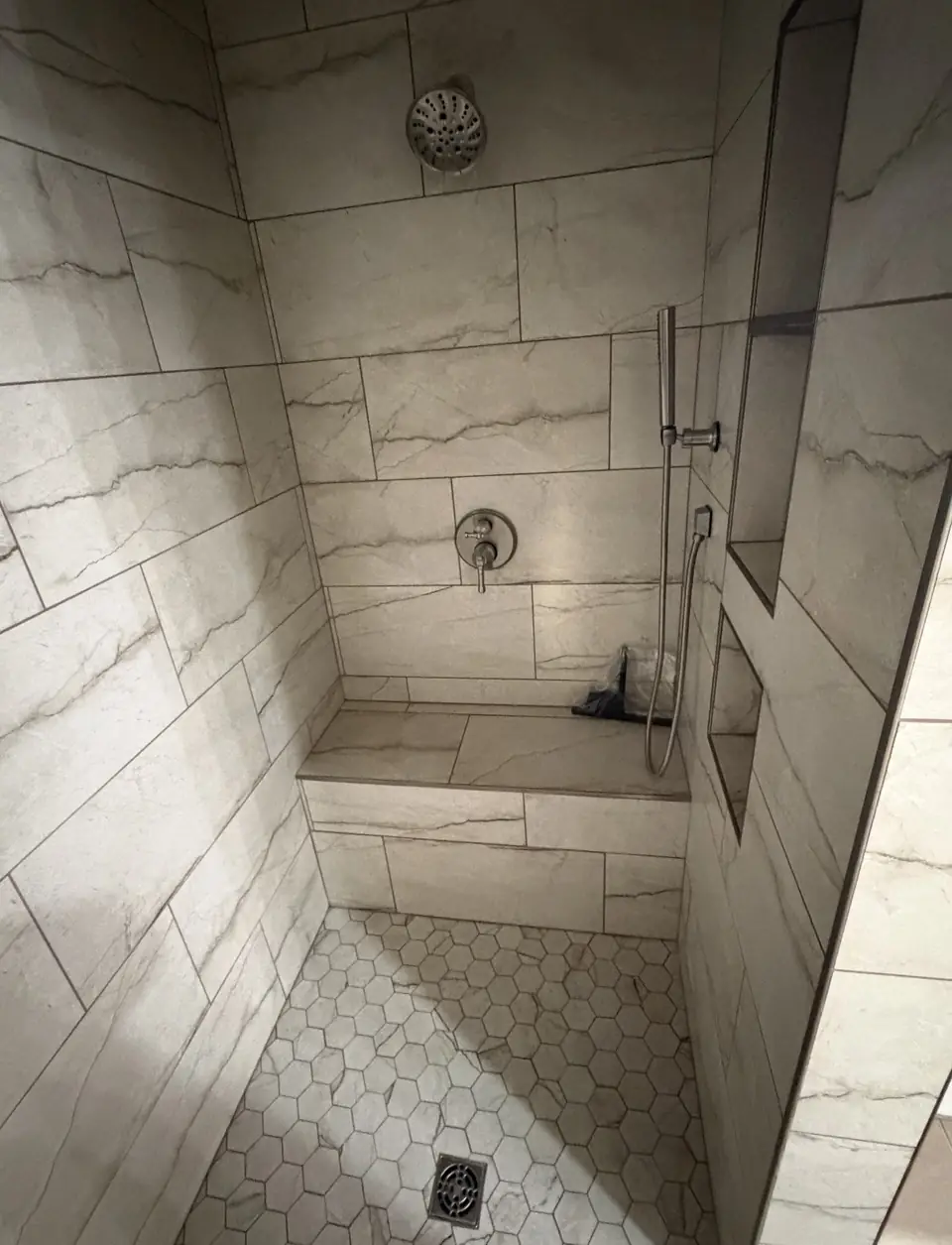Finished tiled walk-in shower with a corner bench